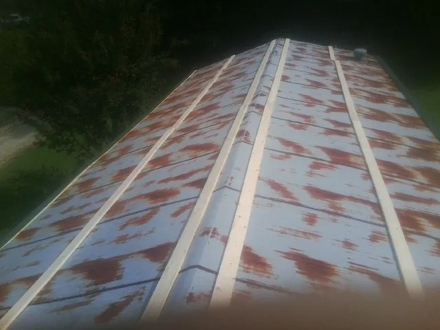 Rusted metal roof panels with new wood purlins before replacement — Storm Damage Roof Repair in Bay Saint Louis by Roofing Brothers