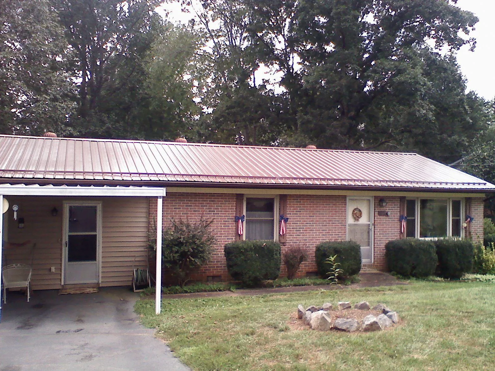Bronze metal roof and carport on a brick ranch home — Roof Repair work by our crew in Bay Saint Louis