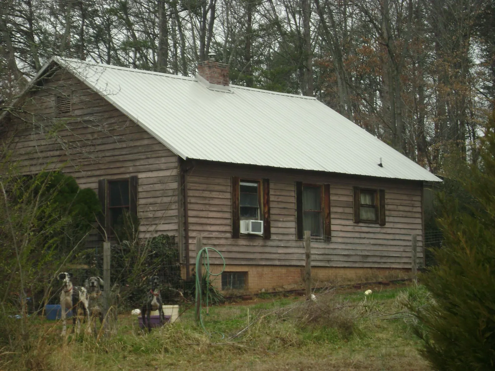 White metal roof on an old wood sided farmhouse, from a Metal Roof Installation job in Bay Saint Louis